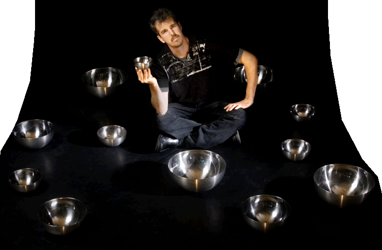 Bowls: Greg Kennedy juggling stainless steel mixing bowls while sitting on the stage