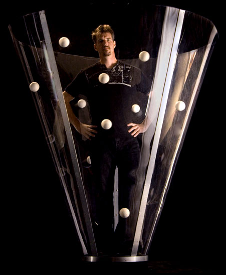 Conic: Greg Keneddy juggling mulitple balls while standing in a large clear cone.